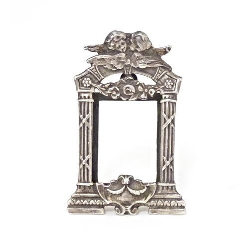 352 - A miniature silver frame with column and cherub detail, marked sterling. Approx. 1 3/4