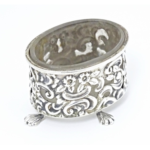 363 - A Victorian silver salt of oval form with embossed decoration and four stylised paw feet, and clear ... 