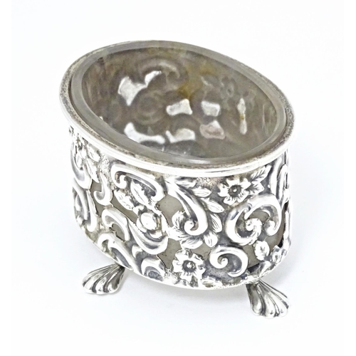 363 - A Victorian silver salt of oval form with embossed decoration and four stylised paw feet, and clear ... 