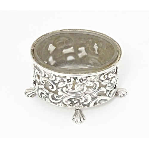 363 - A Victorian silver salt of oval form with embossed decoration and four stylised paw feet, and clear ... 