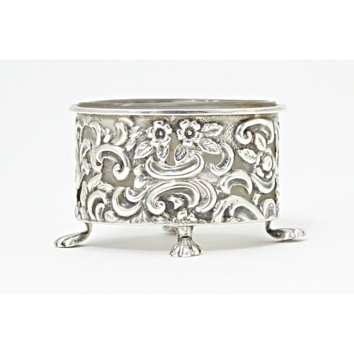 363 - A Victorian silver salt of oval form with embossed decoration and four stylised paw feet, and clear ... 