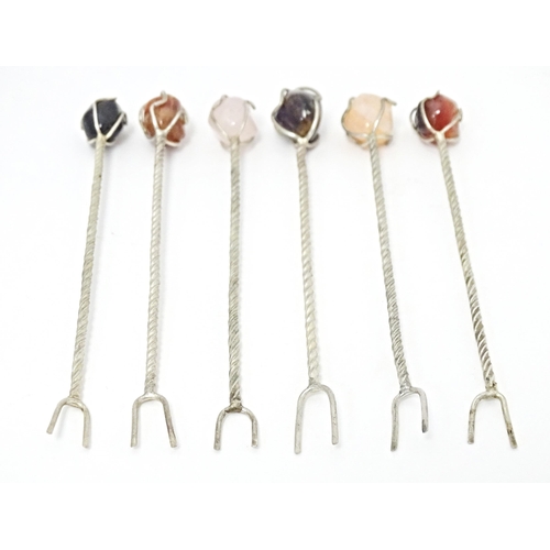 381 - Six white metal cocktail sticks / forks each surmounted with a polished hardstone. Approx. 4 1/2