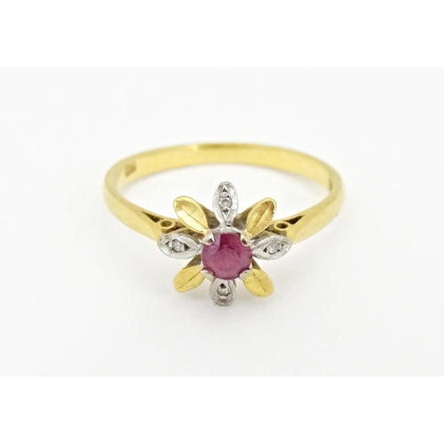 608 - An 18ct gold ring set with a central ruby bordered by chip set diamonds in a floral setting. Ring si... 