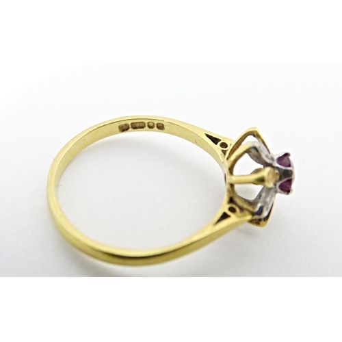 608 - An 18ct gold ring set with a central ruby bordered by chip set diamonds in a floral setting. Ring si... 