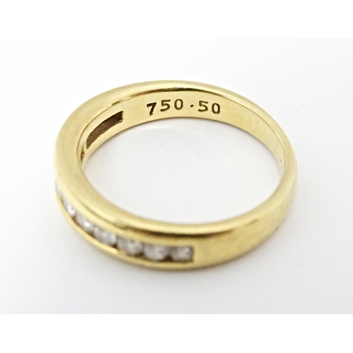 610 - An 18ct gold half eternity ring with channel set diamonds. Ring size approx. L 1/2