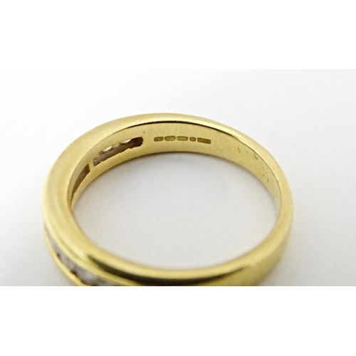 610 - An 18ct gold half eternity ring with channel set diamonds. Ring size approx. L 1/2