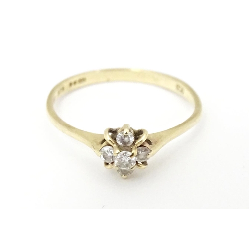 613 - A 9ct gold ring set with four diamonds. Ring size approx. L