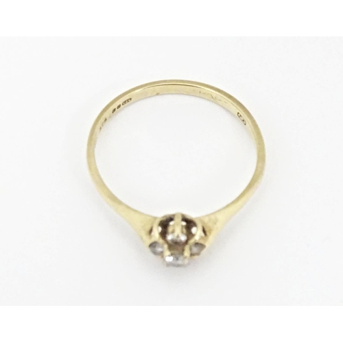 613 - A 9ct gold ring set with four diamonds. Ring size approx. L