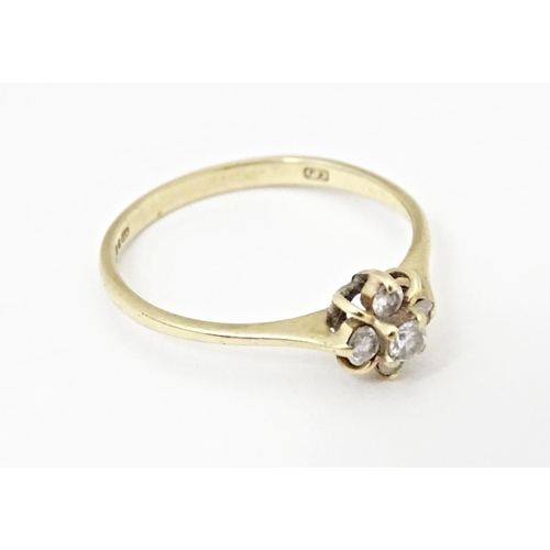 613 - A 9ct gold ring set with four diamonds. Ring size approx. L