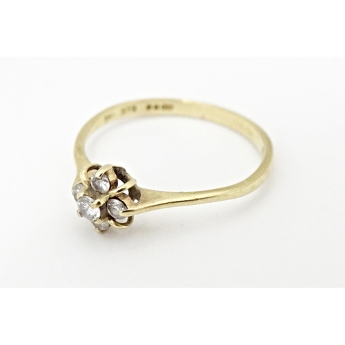 613 - A 9ct gold ring set with four diamonds. Ring size approx. L