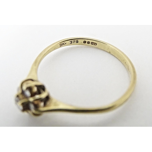 613 - A 9ct gold ring set with four diamonds. Ring size approx. L