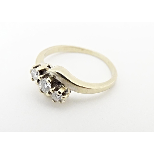 616 - An 18ct gold ring set with three diamonds. Ring size approx. L