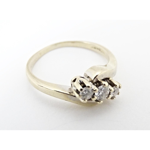 616 - An 18ct gold ring set with three diamonds. Ring size approx. L