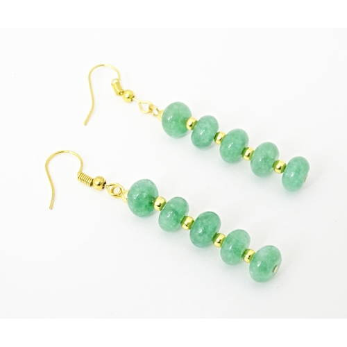 704 - A pair of gilt metal drop earrings set with green beads. Approx 2