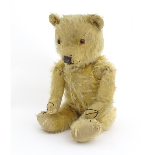 823 - Toy: A 20thC mohair teddy bear with stitched nose, mouth and paws. Approx. 19 1/2