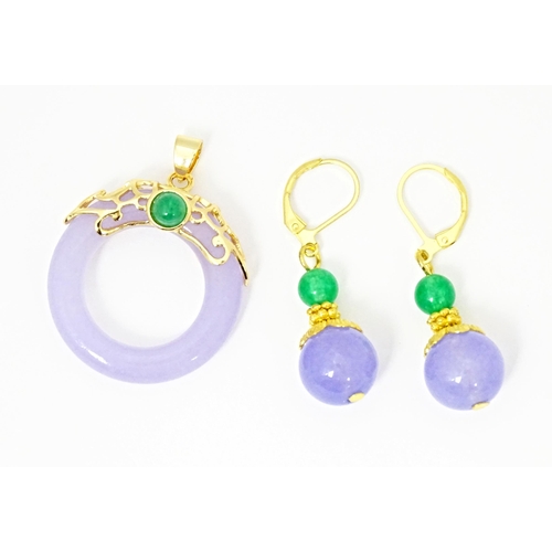 714 - A gilt metal suite of jewellery comprising drop earrings and pendant set with purple and bead hardst... 