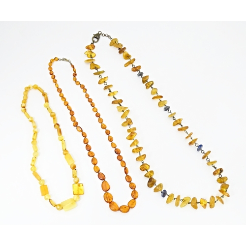 717 - Three various amber coloured bead necklaces. The longest also set with lapis lazuli beads. Approx 20... 