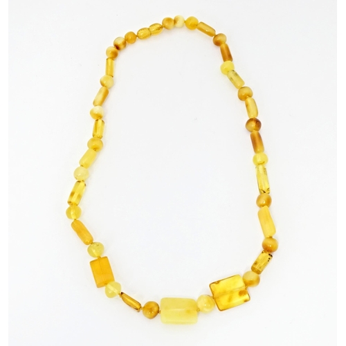 717 - Three various amber coloured bead necklaces. The longest also set with lapis lazuli beads. Approx 20... 