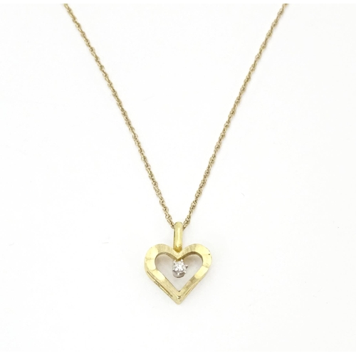 720 - A 9ct gold pendant of heart form set with central diamond, on a gold chain necklace approx 16