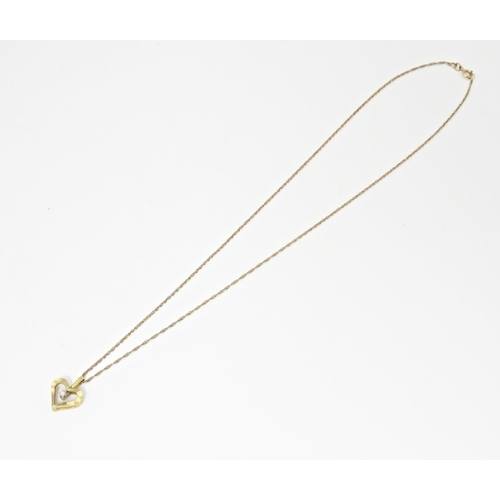 720 - A 9ct gold pendant of heart form set with central diamond, on a gold chain necklace approx 16