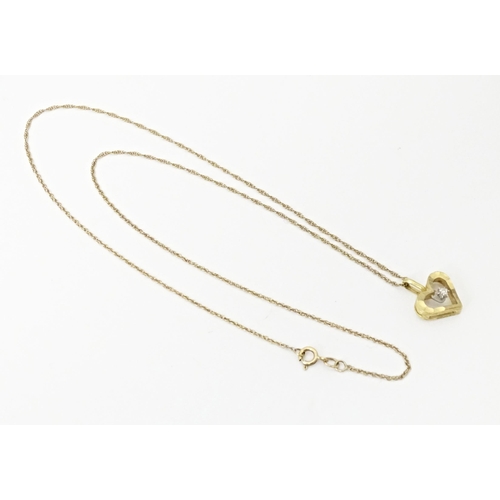 720 - A 9ct gold pendant of heart form set with central diamond, on a gold chain necklace approx 16