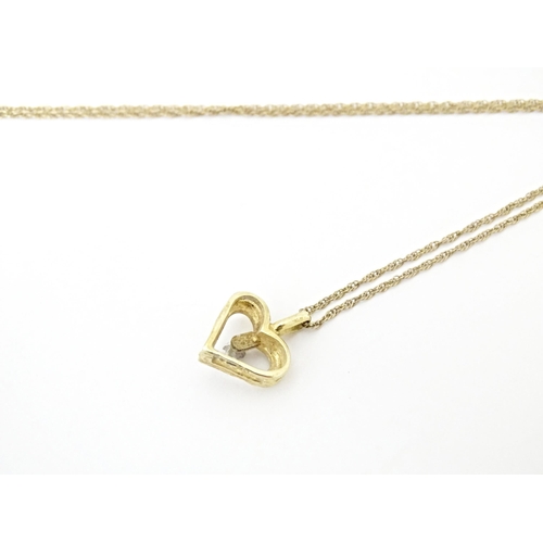 720 - A 9ct gold pendant of heart form set with central diamond, on a gold chain necklace approx 16