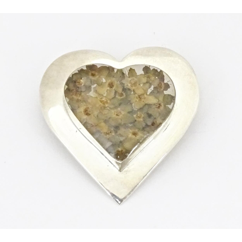 725 - A silver heart shaped brooch with forget me not flower decoration to centre 1 1/4