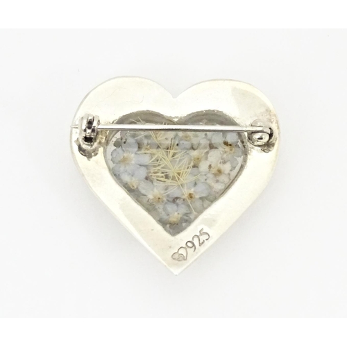 725 - A silver heart shaped brooch with forget me not flower decoration to centre 1 1/4