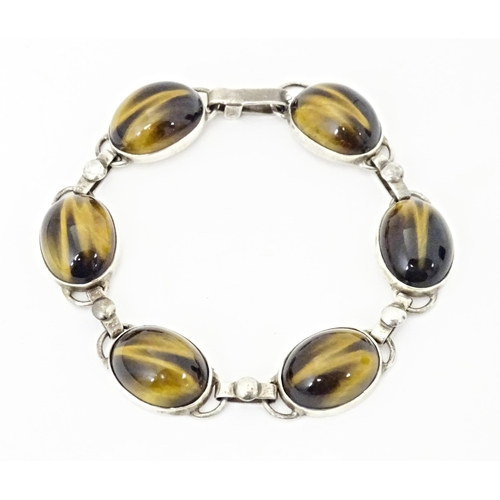 735 - A silver bracelet with 6 tigers eye cabochon. Approx 7 1/2