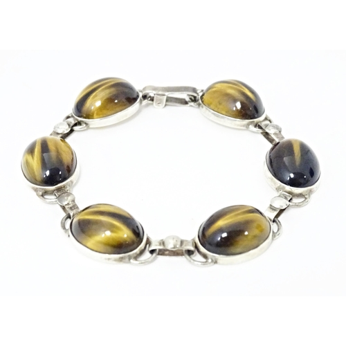 735 - A silver bracelet with 6 tigers eye cabochon. Approx 7 1/2