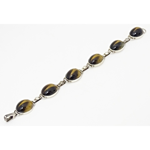 735 - A silver bracelet with 6 tigers eye cabochon. Approx 7 1/2