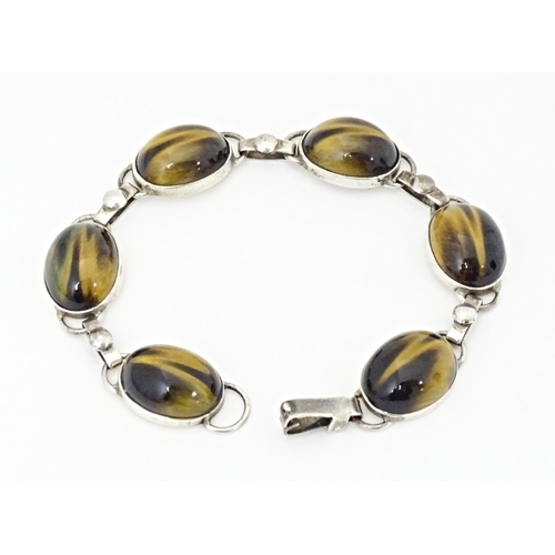 735 - A silver bracelet with 6 tigers eye cabochon. Approx 7 1/2