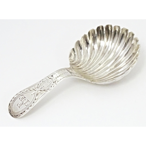 415 - A silver caddy spoon with shell formed bowl and bright cut decoration to handle, hallmarked London 1... 