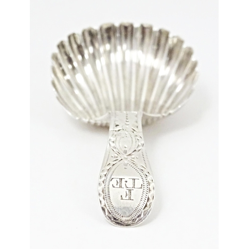 415 - A silver caddy spoon with shell formed bowl and bright cut decoration to handle, hallmarked London 1... 