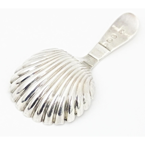 415 - A silver caddy spoon with shell formed bowl and bright cut decoration to handle, hallmarked London 1... 