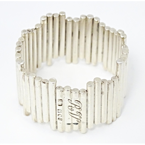 416 - An Elizabeth II silver napkin ring of modernist form, hallmarked London 1976, maker M. B.