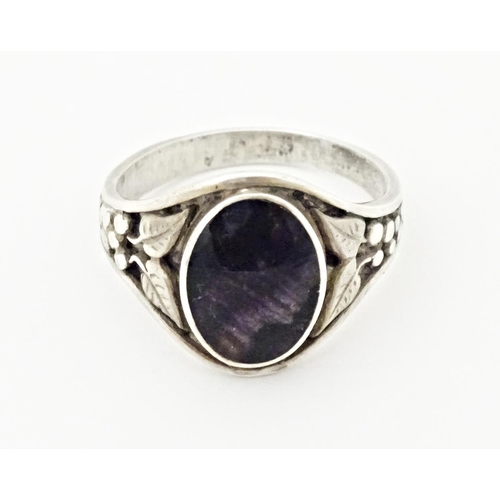 765 - A silver ring set with central Blue John and floral decoration to the shoulders. Marked silver and w... 