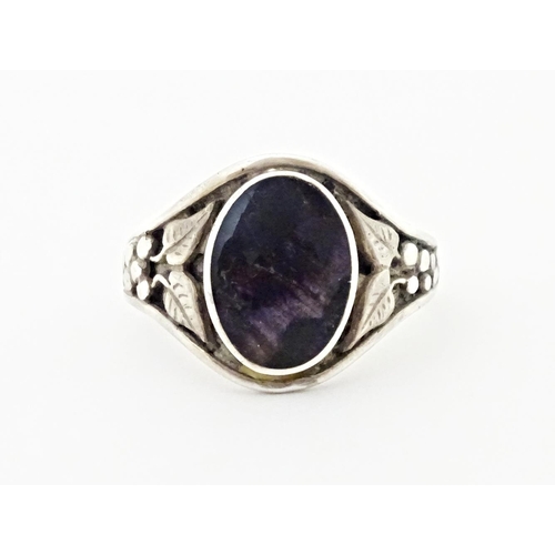 765 - A silver ring set with central Blue John and floral decoration to the shoulders. Marked silver and w... 