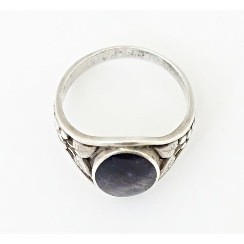 765 - A silver ring set with central Blue John and floral decoration to the shoulders. Marked silver and w... 