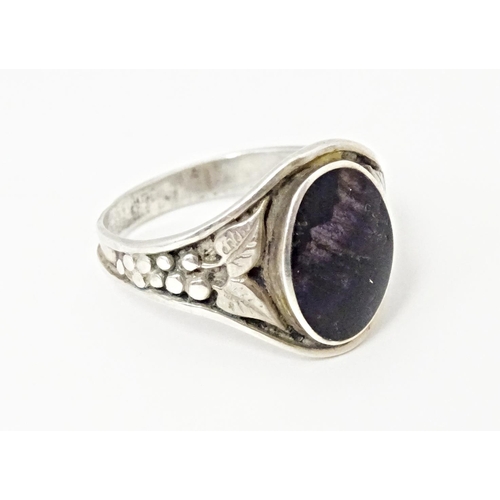 765 - A silver ring set with central Blue John and floral decoration to the shoulders. Marked silver and w... 