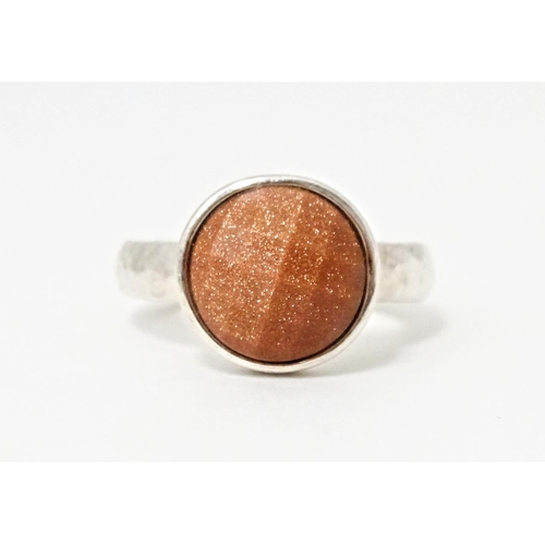 767 - A hallmarked silver ring with hammered finish and set with facet cut goldstone, hallmarks for London... 