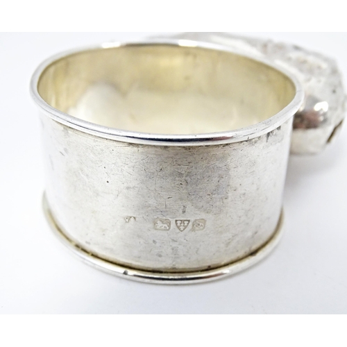 418 - A silver napkin ring mounted on a model of a pig, hallmarked Chester 1924, maker William Vale & Sons... 