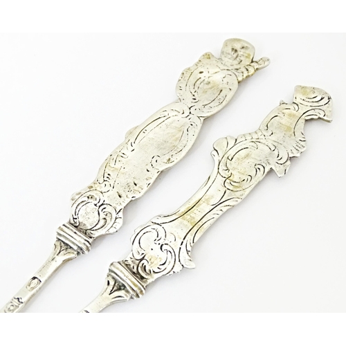 486 - Two Continental white metal serving spoons with figural detail to handles Indistinctly marked. 7 1/2... 