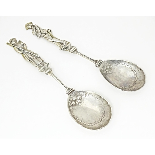 486 - Two Continental white metal serving spoons with figural detail to handles Indistinctly marked. 7 1/2... 