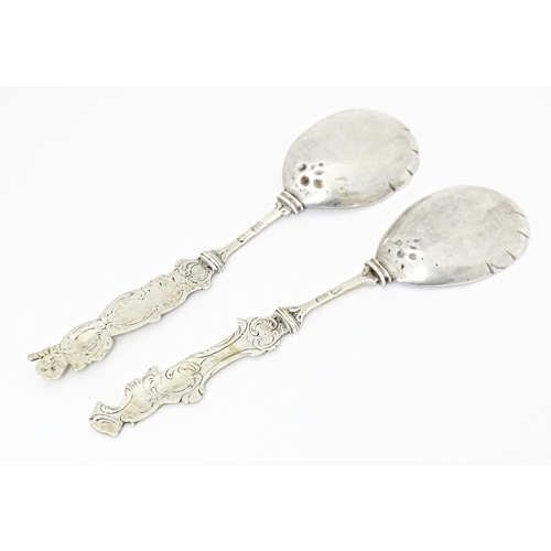 486 - Two Continental white metal serving spoons with figural detail to handles Indistinctly marked. 7 1/2... 