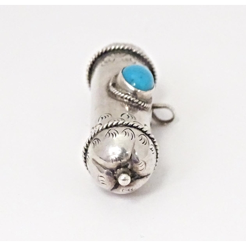 488 - A small white metal container of cylindrical form set with turquoise cabochon and loop hanger.  2