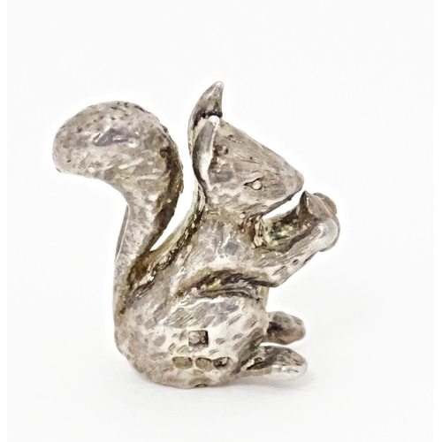 395 - A miniature silver model of a seated squirrel with a nut, hallmarked London 1976. Approx. 1