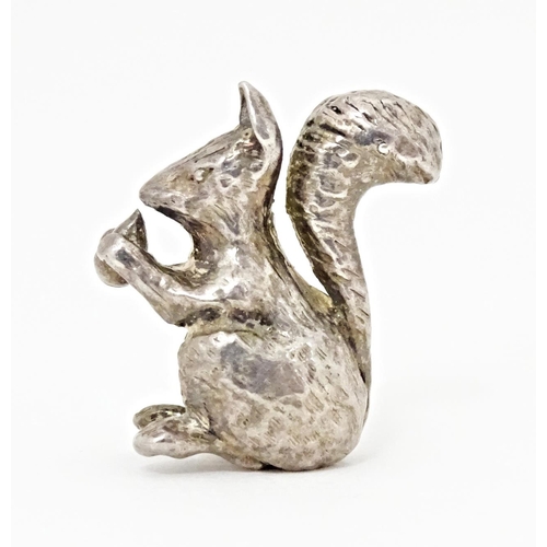 395 - A miniature silver model of a seated squirrel with a nut, hallmarked London 1976. Approx. 1