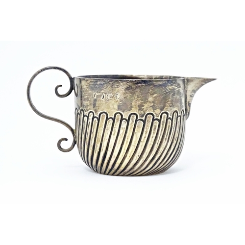 401 - A Victorian silver cream jug with fluted decoration and loop handle, hallmarked Birmingham 1891. App... 