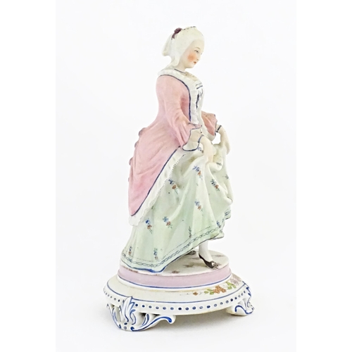 153 - A Continental model of a lady holding her dress skirt, standing on a circular base with floral detai... 